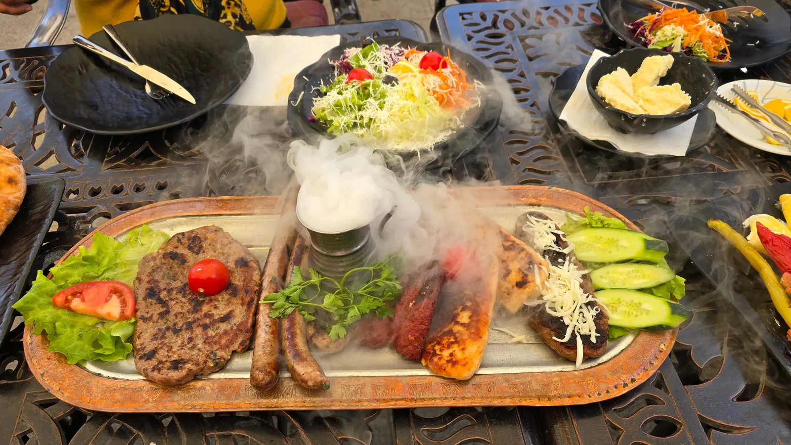 A steaming platter of grilled meats, salads and cheese served at a family-run restaurant in the Balkans
