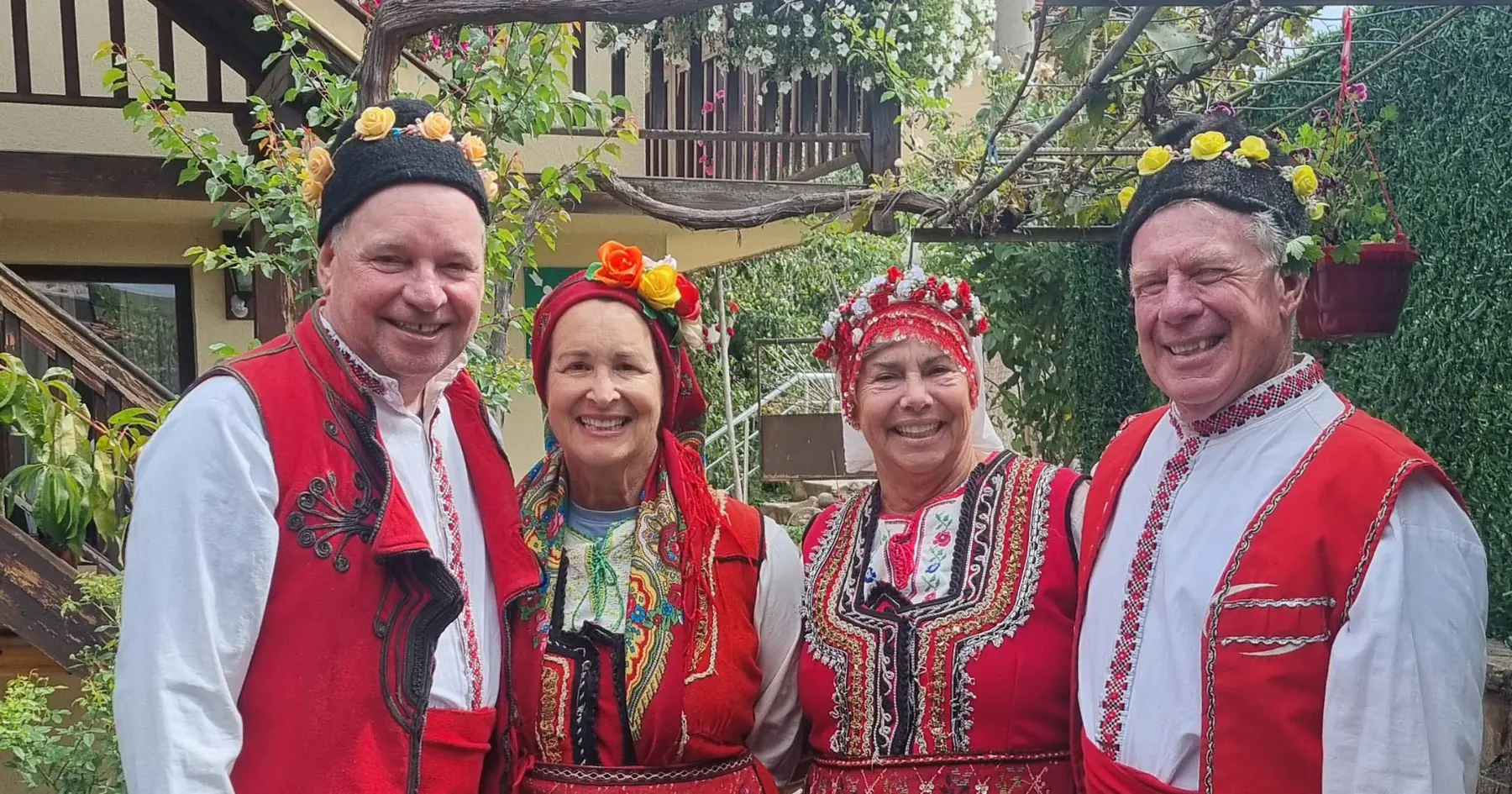 Detour Balkan guests wearing traditional Bulgarian folk costumes with their hosts