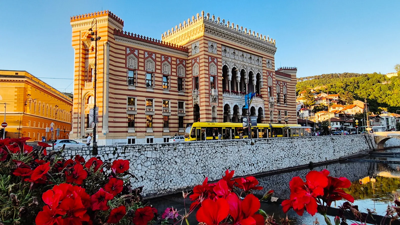 Sarajevo City Hall in Bosnia & Herzegovina, with a yellow tram passing in front